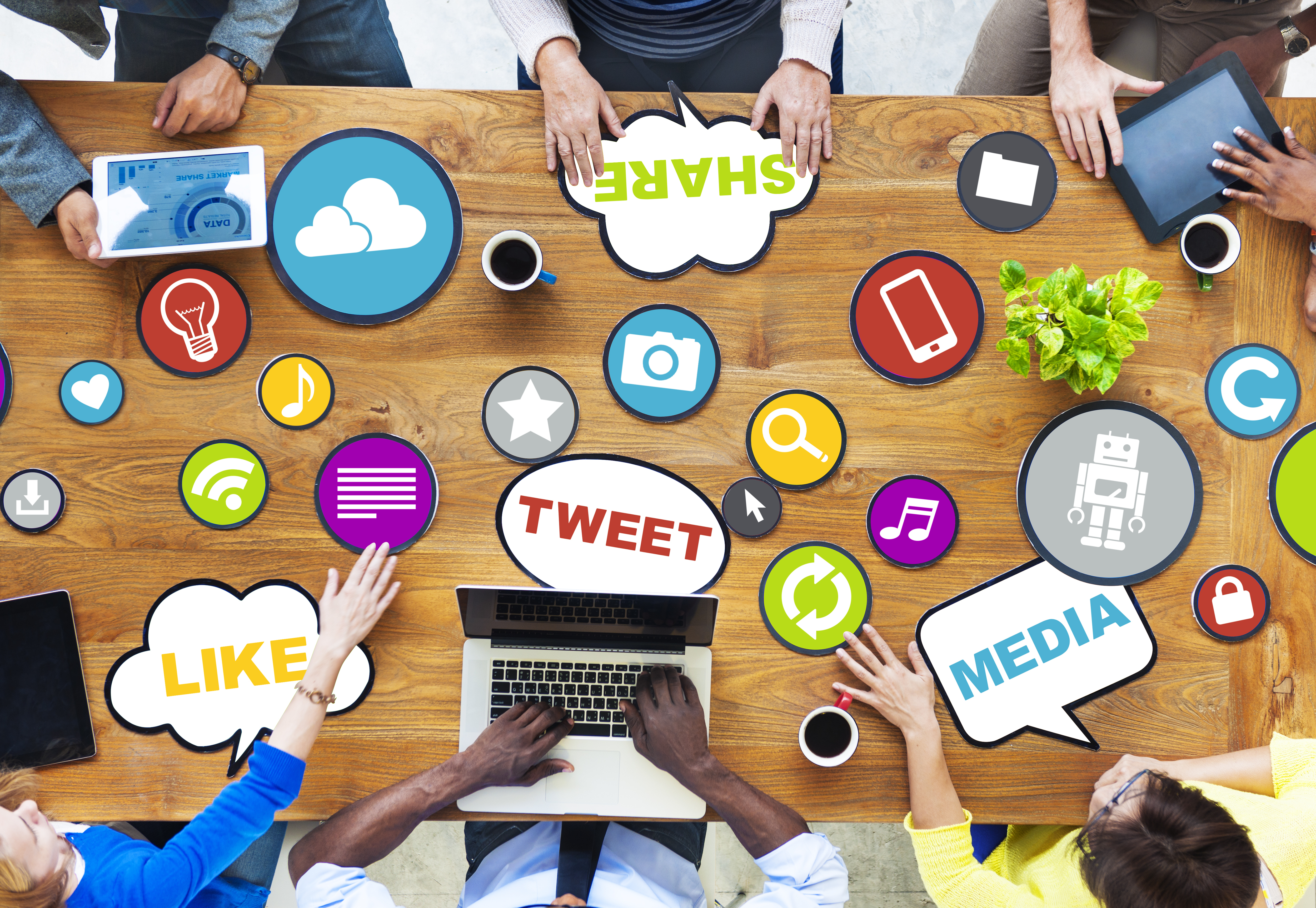 A team working around a desk decorated with social media terms and icons